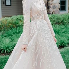 a woman in a wedding dress poses for the camera