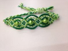 two green and white bracelets sitting on top of a table