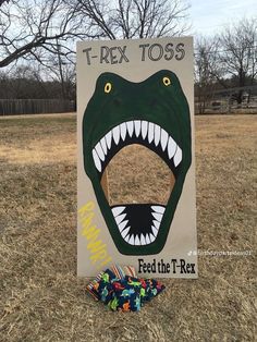 a sign that says t - rex toss with an alligator's mouth on it