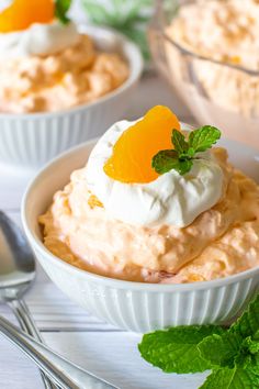 orange dream salad with whipped cream and fresh mint garnish in small white bowls