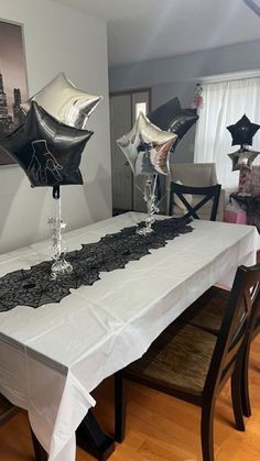 black and white balloons are placed on the table for an elegant dinner or birthday party