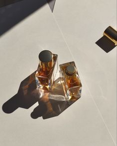 two bottles of perfume sitting on top of a table