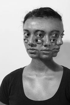 a woman with her face covered in black and white makeup is posing for the camera