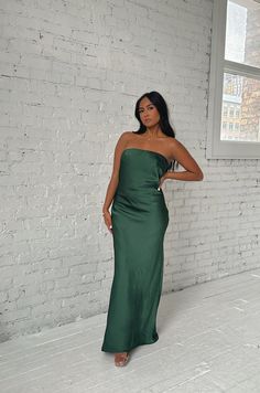 This Emerald Green Maxi Dress will make you feel elegant and special. Crafted from luxuriously smooth satin silky, the dress features a strapless silhouette with a cowl back and a waisted tie. The long length flatters any figure and makes this dress perfect for a formal occasion. emerald green strapless dramatic cowl back back bow tie relaxed fit long length 100% polyester model is wearing a small Satin Floor-length Slip Dress For Date Night, Floor-length Satin Slip Dress For Date Night, Strapless Slip Dress With Fitted Bodice For Date Night, Formal Strapless Dress With Satin Finish, Strapless Bias Cut Dress For Prom, Strapless Bias Cut Prom Dress, Green Satin Maxi Dress For Gala, Green Satin Sleeveless Dress For Gala, Green Strapless Dress With Straight Neckline For Evening