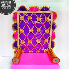 a purple and pink backdrop with gold trimmings on the sides, along with decorative decorations