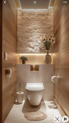 a white toilet sitting inside of a bathroom next to a wooden paneled wall and floor