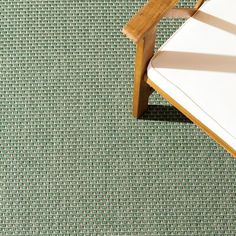 a wooden chair sitting on top of a green carpet