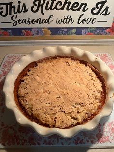 a pie sitting on top of a table next to a sign that says this kitchen has seasoned with love