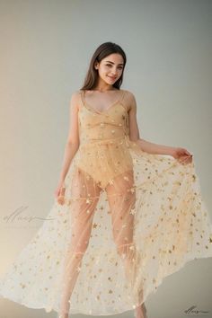 a woman is posing for the camera wearing a sheer dress with stars all over it