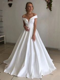 a woman in a white wedding dress posing for the camera