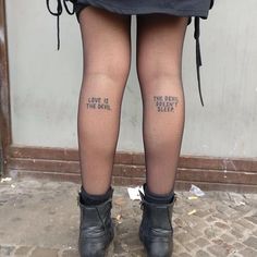 the legs and ankles of a woman with words written on her tights that read, love is the devil sleep