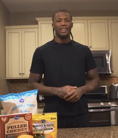 a man standing in a kitchen next to some food