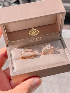 two wedding rings in a box with the lid open to show it's inside