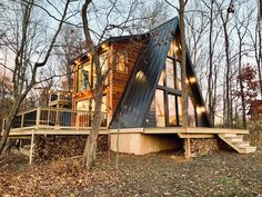 a small cabin in the woods with stairs leading up to it's second floor