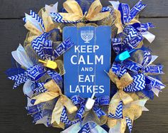 a wreath that says keep calm and eat latkes with a blue sign on it