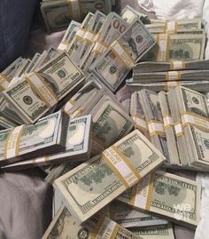 a pile of money sitting on top of a bed