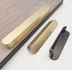 an assortment of brass handles on a white surface