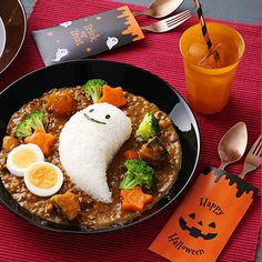 a bowl filled with food on top of a table next to a fork and spoon