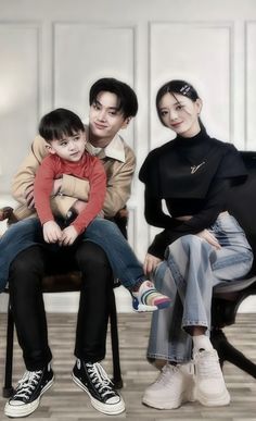 three people sitting on a chair with one holding a small child