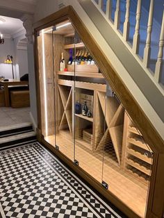 a wine cellar under the stairs in a house