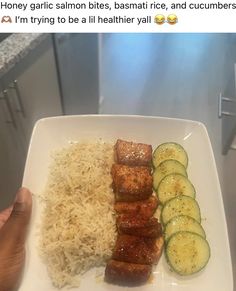 someone is holding up a plate with rice, meat and cucumbers on it