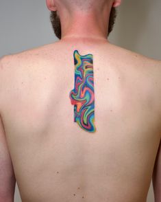 a man with a tattoo on his back has a colorful piece of art on his shoulder