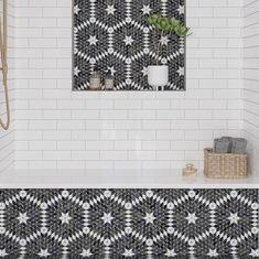 a bathroom with black and white tiles on the wall, flooring and bathtub