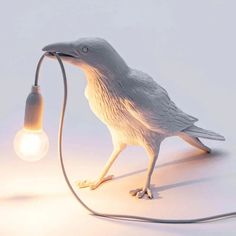 a bird lamp with a light bulb attached to it's body and the head turned upside down