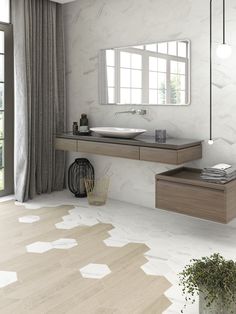 a bathroom with a sink, mirror and plant on the floor in front of it