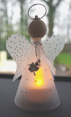 an angel shaped candle holder sitting on top of a table