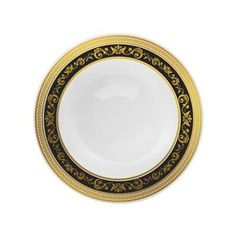 a black and gold plate with an ornate design on the rim, against a white background