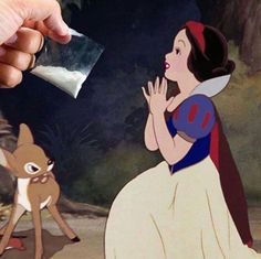 a hand is holding up a piece of paper to an image of snow white and the seven dwarfs