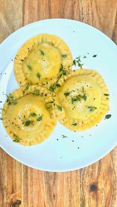 three small pastries on a white plate with parsley sprinkled on top