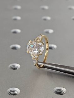 a close up of a diamond ring on top of a piece of metal