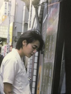 a young man standing in front of a vending machine