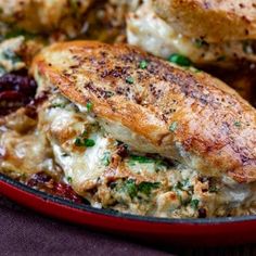 chicken breast with cranberry sauce in a red skillet on a wooden table