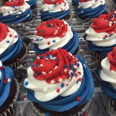 cupcakes with red, white and blue frosting are in plastic trays