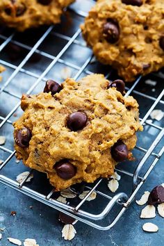 chocolate chip cookies cooling on a wire rack with oats and almonds around them