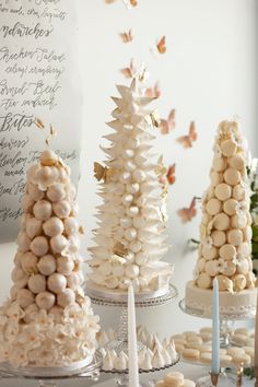 there are many different types of desserts on the table with white frosted trees