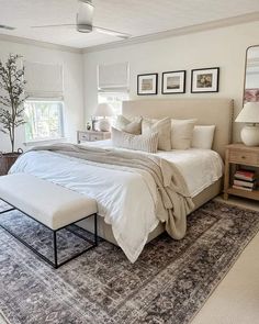 a large white bed sitting in a bedroom on top of a rug