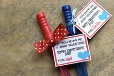 two valentine's day candy sticks tied to each other with red and blue ribbons