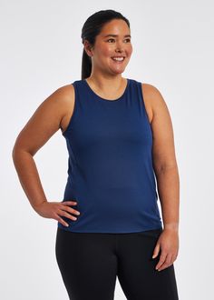 a woman in blue tank top standing with her hands on her hips