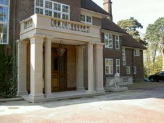 a large brick building with columns on the front and an entry way leading to it