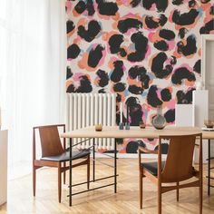 a dining room table with two chairs and a large wall mural behind it in the background