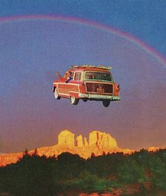 a van is flying over the mountains with a rainbow in the sky and a person laying on top