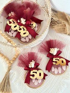 two baskets filled with cookies and candy on top of a white table next to a tassell