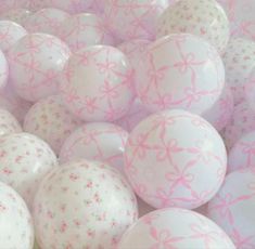 many white and pink balloons with bows on them