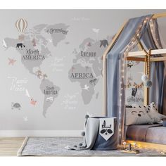 a child's bedroom with a world map wall decal in grey and pink