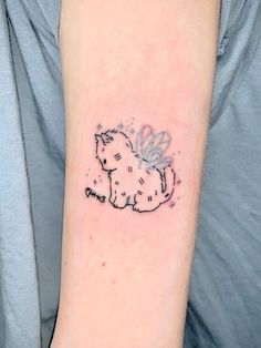 a small tattoo on the arm of a woman's left arm, depicting a cat with wings