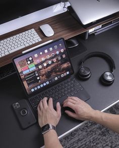 a person sitting at a desk with a laptop computer and headphones on their laps